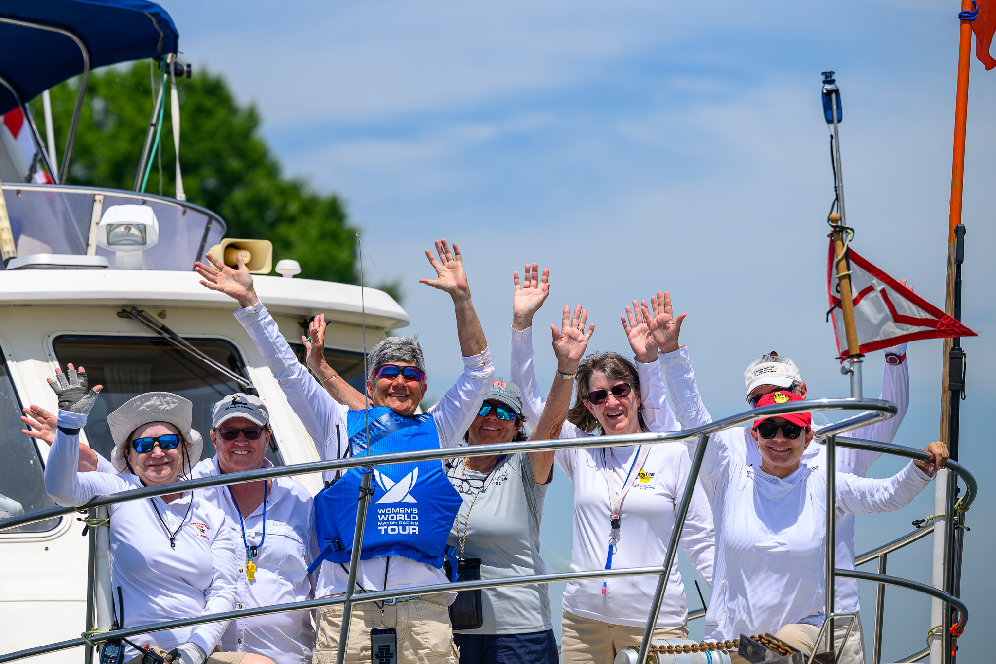 Crew waving from the boat after racing
